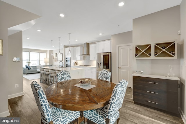 dining room with wood finished floors, baseboards, and recessed lighting