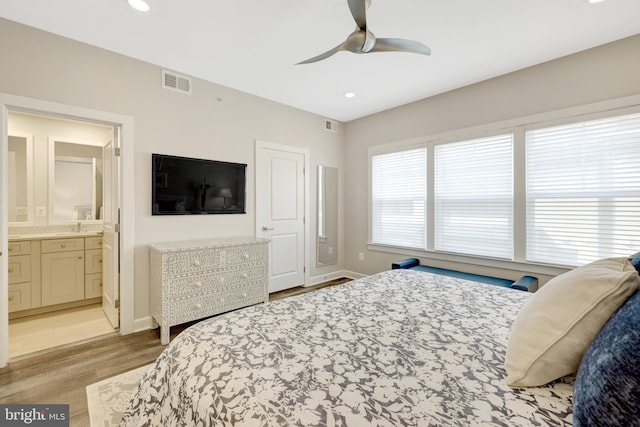 bedroom featuring light wood finished floors, baseboards, a ceiling fan, recessed lighting, and ensuite bathroom