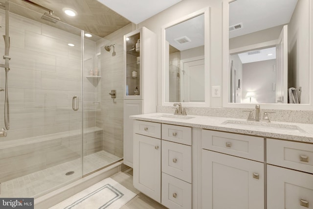 full bathroom with a stall shower and double vanity