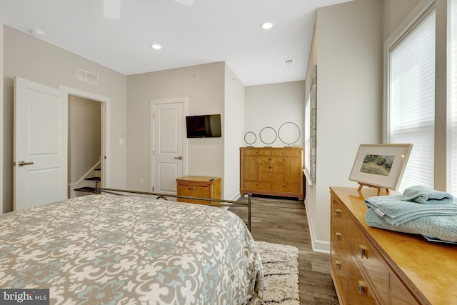 bedroom featuring wood finished floors, baseboards, and recessed lighting