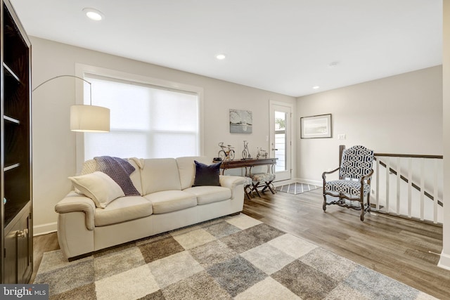 living room with wood finished floors, baseboards, and recessed lighting