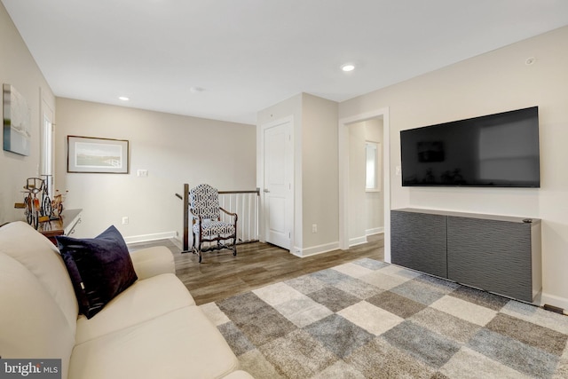 living room with wood finished floors, baseboards, and recessed lighting