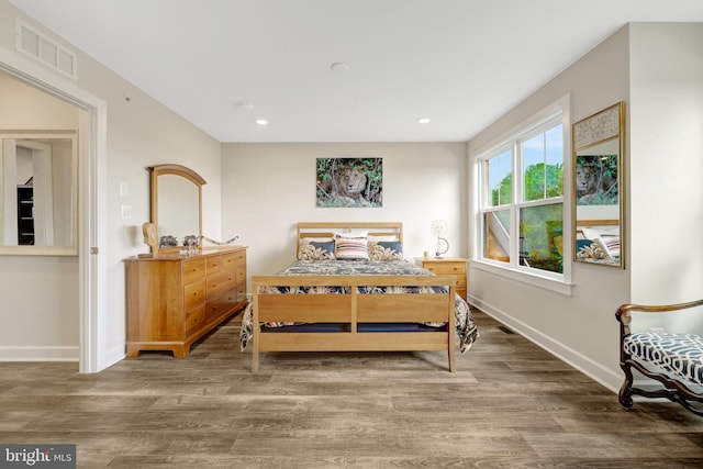 bedroom with wood finished floors, baseboards, and recessed lighting