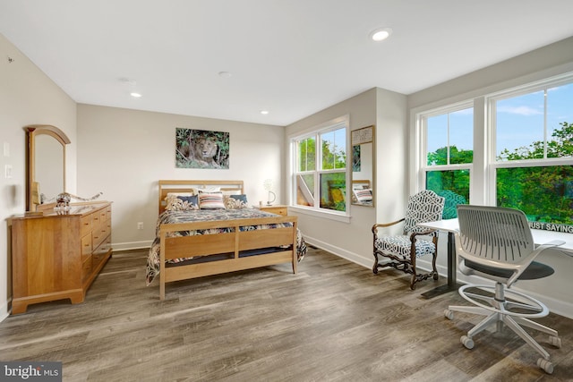 bedroom featuring wood finished floors, baseboards, and recessed lighting