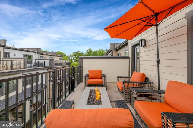 balcony with an outdoor living space with a fire pit