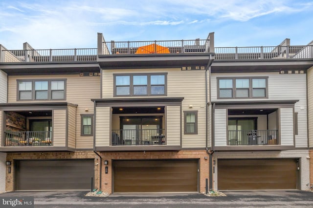 rear view of property featuring an attached garage and brick siding