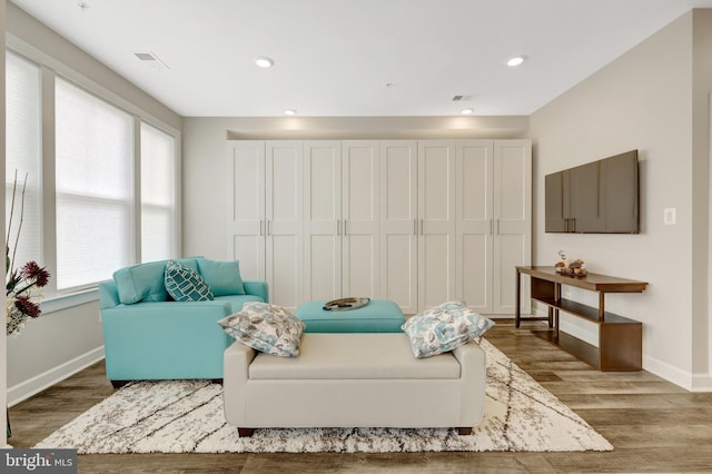 living area featuring wood finished floors, baseboards, and recessed lighting