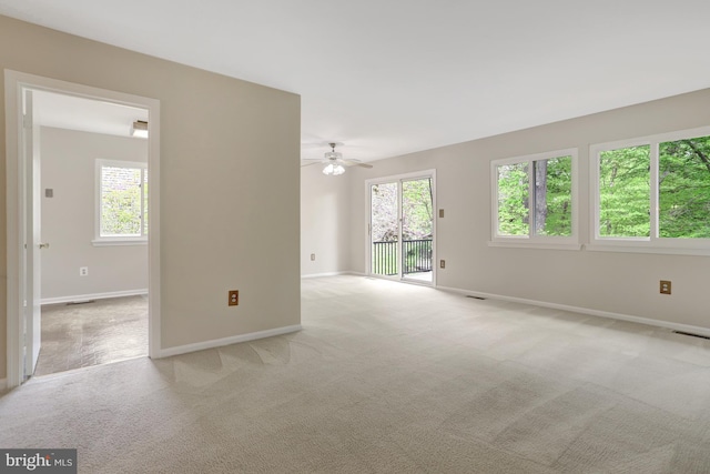 unfurnished room with carpet floors, baseboards, visible vents, and ceiling fan