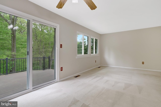 empty room featuring baseboards, light carpet, a ceiling fan, and visible vents