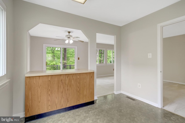 unfurnished room featuring ceiling fan, visible vents, baseboards, tile patterned floors, and carpet flooring