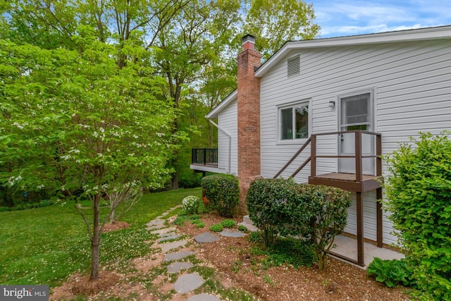 exterior space featuring a lawn and a chimney
