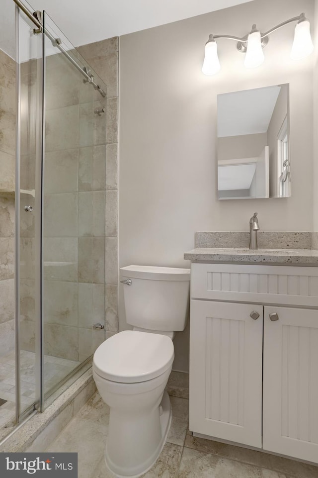 full bath with vanity, a stall shower, and toilet