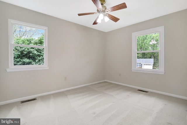 empty room featuring visible vents, baseboards, and plenty of natural light