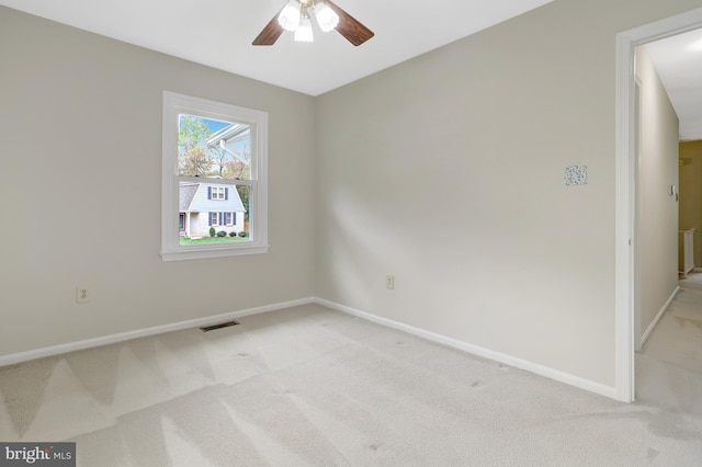 unfurnished room with baseboards, visible vents, light carpet, and ceiling fan