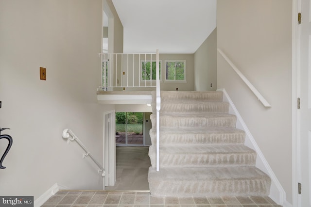 stairway with baseboards and carpet
