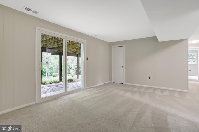 empty room featuring baseboards, visible vents, and light carpet