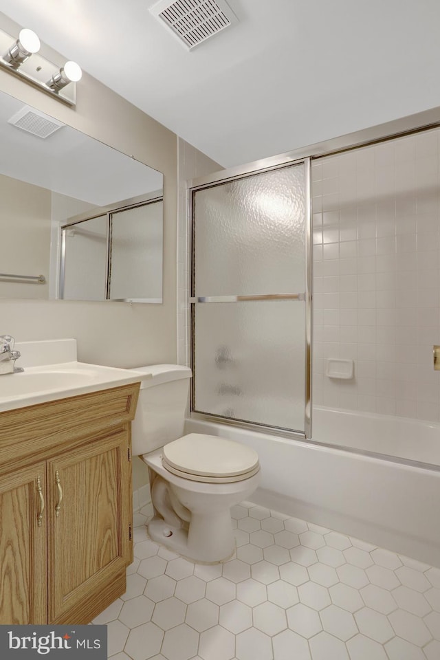 full bath featuring tile patterned flooring, vanity, toilet, visible vents, and bath / shower combo with glass door