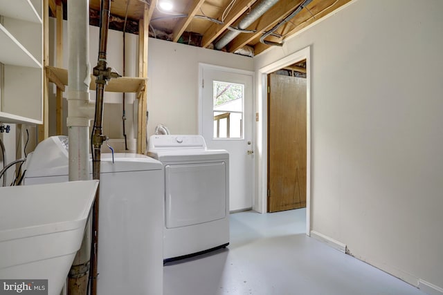 washroom featuring laundry area, a sink, baseboards, and washing machine and clothes dryer