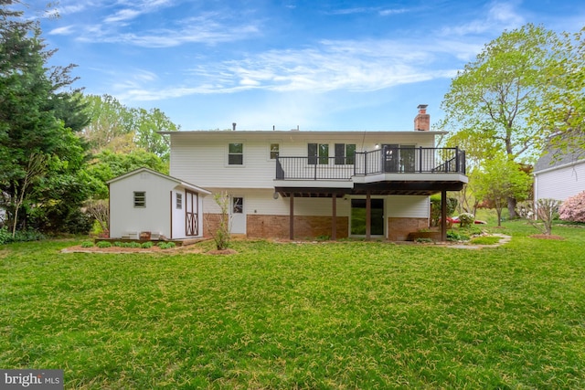 rear view of house featuring a chimney, a lawn, an outbuilding, a wooden deck, and brick siding