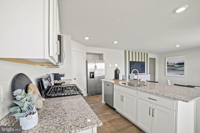 111 Yurok Ct, Winchester, VA 22602 - kitchen with a sink, light wood-style floors, stainless steel appliances, a center island with sink, and white cabinetry