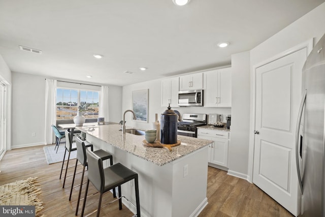 111 Yurok Ct, Winchester, VA 22602 - kitchen featuring a kitchen breakfast bar, a sink, an island with sink, appliances with stainless steel finishes, and visible vents