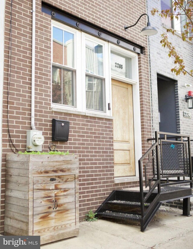 view of exterior entry with brick siding