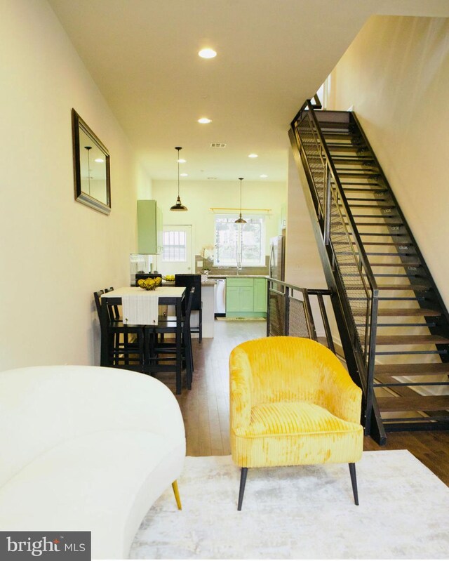 living area featuring visible vents, dark wood-style floors, recessed lighting, and stairs
