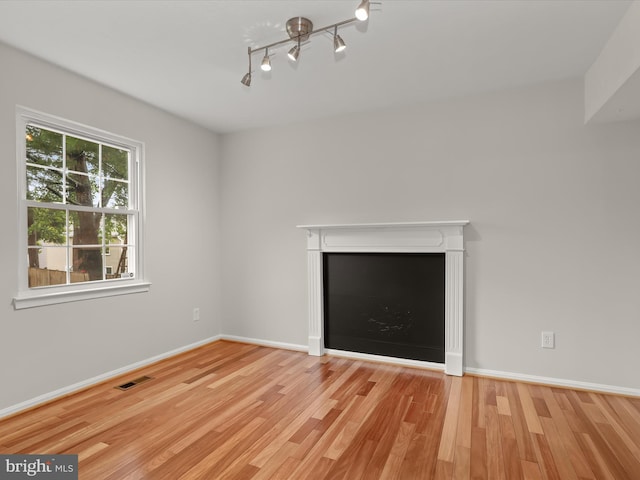 3826 Perryhurst, Nottingham, MD 21236 - unfurnished living room with wood finished floors, baseboards, and rail lighting