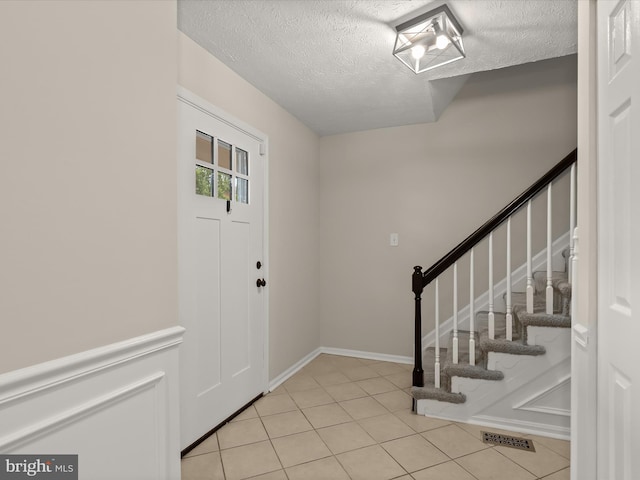 3826 Perryhurst, Nottingham, MD 21236 - entrance foyer with a textured ceiling, stairs, and light tile patterned floors