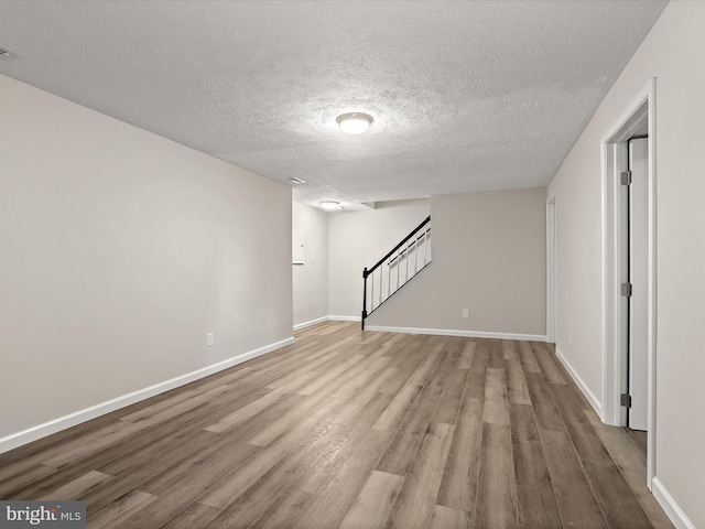 3826 Perryhurst, Nottingham, MD 21236 - finished basement featuring a textured ceiling, wood finished floors, stairway, and baseboards