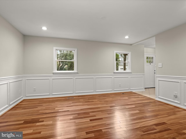 3826 Perryhurst, Nottingham, MD 21236 - empty room featuring healthy amount of natural light, light wood-type flooring, wainscoting, a decorative wall, and recessed lighting