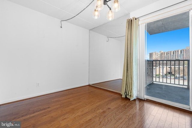 2648 Redcoat Dr Unit 99 1C, Alexandria, VA 22303 - empty room with a chandelier, wood finished floors, baseboards, and a view of city
