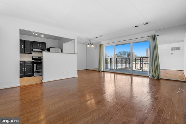 2648 Redcoat Dr Unit 99 1C, Alexandria, VA 22303 - unfurnished living room with baseboards, wood finished floors, visible vents, and a chandelier