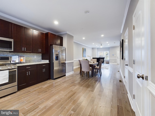 1519 E Chase St, Baltimore, MD 21213 - kitchen featuring appliances with stainless steel finishes, light wood-style flooring, baseboards, backsplash, and ornamental molding