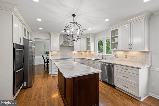 kitchen featuring appliances with stainless steel finishes, decorative backsplash, a sink, and an inviting chandelier