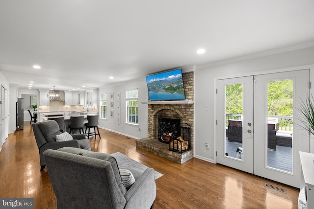 living area featuring visible vents, ornamental molding, a fireplace, and recessed lighting