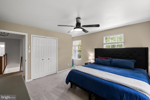 carpeted bedroom with a closet, baseboards, and ceiling fan