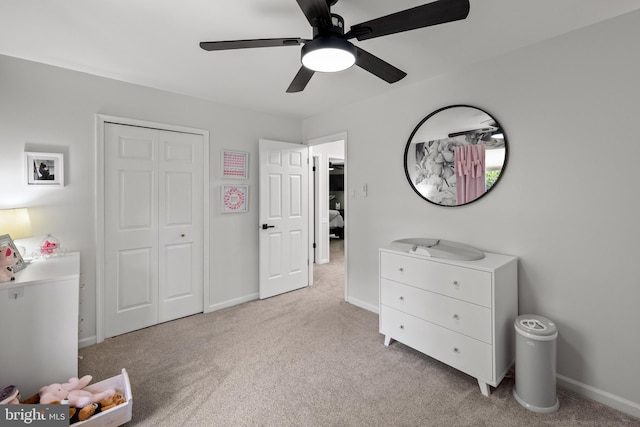 bedroom featuring baseboards, light carpet, and a closet