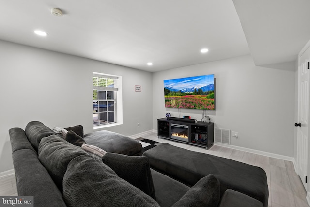 living area featuring recessed lighting, baseboards, and light wood-style flooring