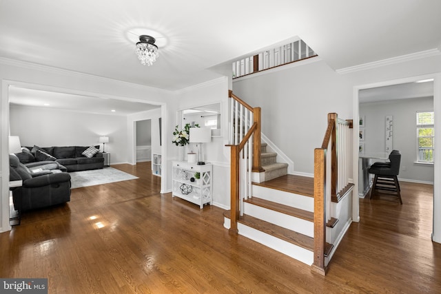 staircase with crown molding, baseboards, and wood finished floors