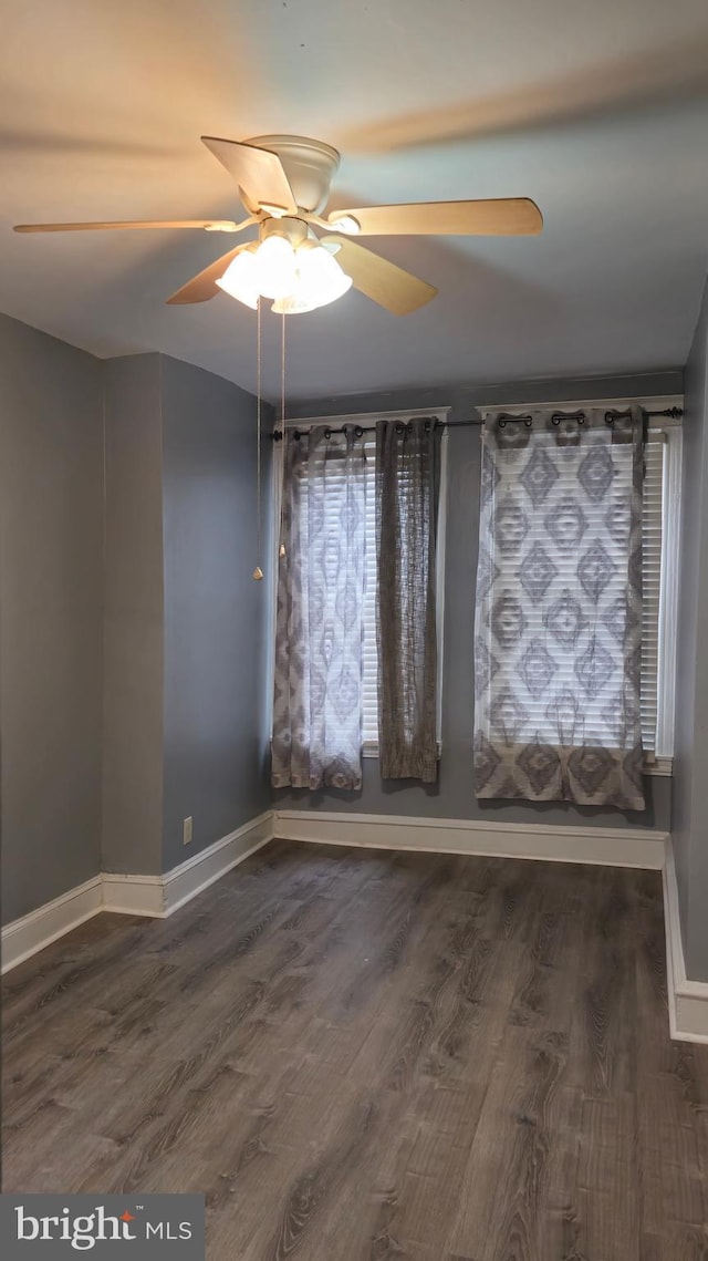 unfurnished room featuring baseboards, a ceiling fan, and wood finished floors