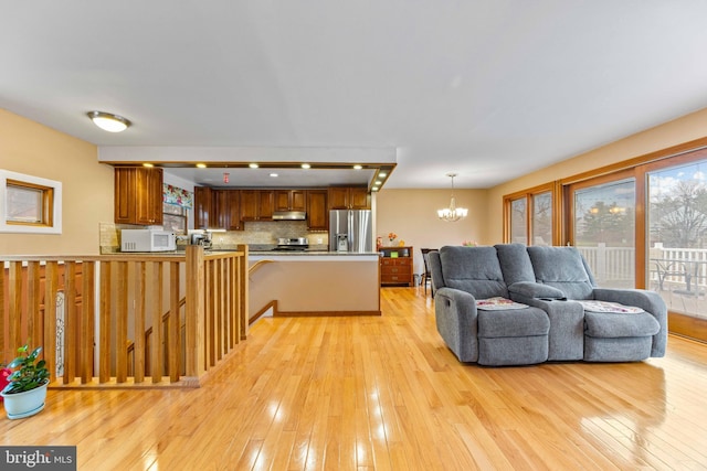 living area featuring light wood finished floors and an inviting chandelier