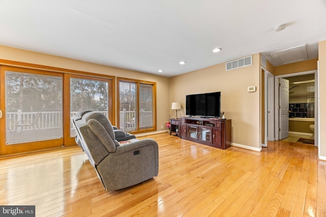 living room with recessed lighting, light wood-style floors, visible vents, and baseboards