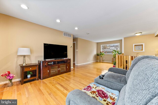 living room featuring wood finished floors, visible vents, and baseboards