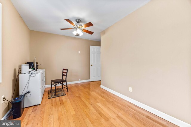 interior space featuring light wood-type flooring, a ceiling fan, and baseboards