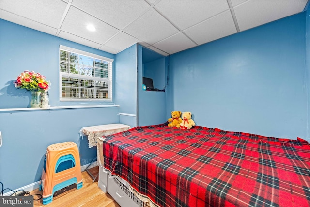 bedroom featuring wood finished floors, a paneled ceiling, and recessed lighting