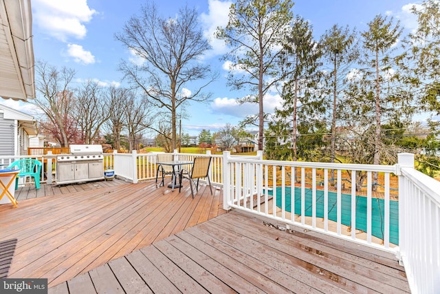 wooden deck featuring outdoor dining area, a grill, and a covered pool
