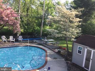 view of pool with a fenced in pool and an outbuilding