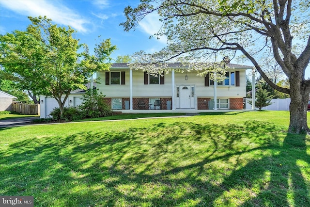 raised ranch with fence and a front yard