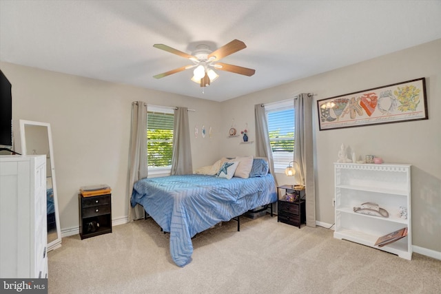 bedroom with carpet floors, a ceiling fan, baseboards, and multiple windows